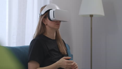 Frau-Nutzt-HMD-Display,-Sitzt-Zu-Hause,-Interaktive-Unterhaltung-Und-Bildung-Mit-Modernem,-Weißem-VR-Headset